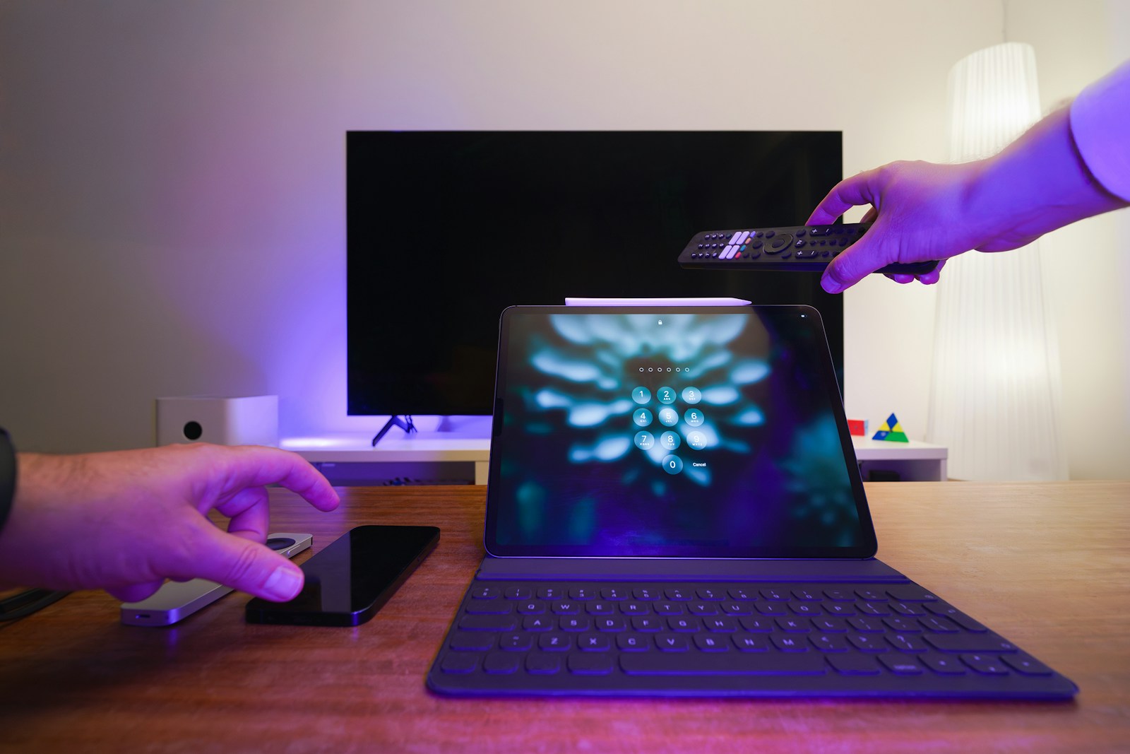 Pessoa a configurar IPTV em casa com TV, tablet, telemovel e comando