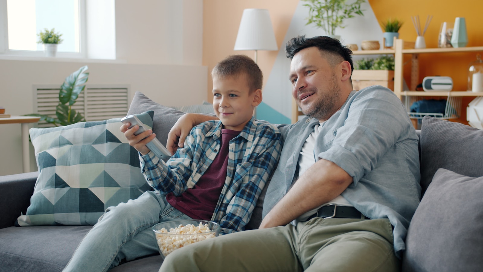 Familia a ver televisao no sofa enquanto escolhe IPTV em Portugal